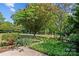 Landscaped front yard featuring mature trees, flowers, and lush greenery at 907 Lingfield Ln, Waxhaw, NC 28173