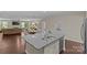 An open kitchen island features granite counters and a double sink with an adjacent living space at 907 Lingfield Ln, Waxhaw, NC 28173