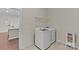 Bright laundry room with modern washer and dryer, shelving, and tile flooring at 907 Lingfield Ln, Waxhaw, NC 28173