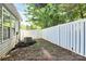 Spacious backyard with a white fence, mulch, and a path of grass providing a private outdoor space at 9212 Scotts Elm Ct, Charlotte, NC 28215