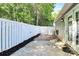 Backyard patio featuring a privacy fence, brick pavers, and landscaped garden beds at 9212 Scotts Elm Ct, Charlotte, NC 28215