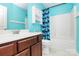 Well-lit bathroom with a sleek vanity, modern fixtures, and a shower tub combination featuring stylish blue curtains at 9212 Scotts Elm Ct, Charlotte, NC 28215