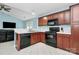 Functional kitchen with wood cabinets and black appliances and tile floors at 9212 Scotts Elm Ct, Charlotte, NC 28215