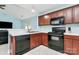 Functional kitchen with wood cabinets and black appliances and tile floors at 9212 Scotts Elm Ct, Charlotte, NC 28215