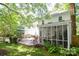Back deck featuring a screened porch, a dining table, and well-manicured landscaping at 1023 Evian Ln, Matthews, NC 28105