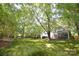 A spacious lawn with mature trees surrounds a charming white house with a screened porch at 1023 Evian Ln, Matthews, NC 28105