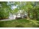 Expansive backyard featuring a spacious lawn, mature trees, and a white two-story house at 1023 Evian Ln, Matthews, NC 28105