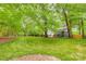 Expansive backyard featuring lush lawn, mature trees, and screened porch, creating a private outdoor retreat at 1023 Evian Ln, Matthews, NC 28105