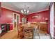 Elegant dining room with red walls, hardwood floors, chandelier, and classic decor at 1023 Evian Ln, Matthews, NC 28105