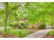 Traditional brick home with manicured lawn, mature trees, and a gated driveway at 1023 Evian Ln, Matthews, NC 28105