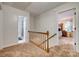 Upstairs hallway with neutral carpet and staircase featuring wood handrail at 1023 Evian Ln, Matthews, NC 28105