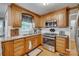 Well-lit kitchen featuring wood cabinets, stainless steel appliances, and granite countertops at 1023 Evian Ln, Matthews, NC 28105