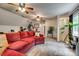 Living room with a large red sectional sofa, neutral carpet, and exercise equipment at 1023 Evian Ln, Matthews, NC 28105