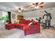 Comfortable living room with sectional sofa, exercise equipment, and ceiling fans at 1023 Evian Ln, Matthews, NC 28105