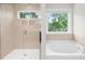 Spa-like bathroom with a glass-enclosed shower and separate soaking tub, surrounded by natural light at 106 Kirsche Ct, Mooresville, NC 28115