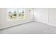 Sunny bedroom with neutral carpet and a window looking out to the neighborhood at 106 Kirsche Ct, Mooresville, NC 28115