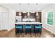 Stylish kitchen island with barstool seating, pendant lights, and stainless steel appliances at 106 Kirsche Ct, Mooresville, NC 28115