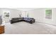 Spacious living room featuring plush carpeting, ample natural light, and a comfortable leather sectional at 106 Kirsche Ct, Mooresville, NC 28115