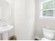 Classic powder room featuring a round mirror, pedestal sink, and wood-look flooring at 106 Kirsche Ct, Mooresville, NC 28115