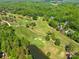 Aerial shot of a golf course, revealing pristine fairways, greens, and a serene pond at 108 Augusta Dr, Statesville, NC 28625
