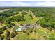 Aerial view of a lush golf course with a clubhouse, pool, and parking lot at 108 Augusta Dr, Statesville, NC 28625