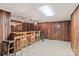 Basement bar area with wood paneling, bar, shelving, and carpeted floor at 108 Augusta Dr, Statesville, NC 28625