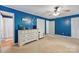 Bedroom featuring blue walls, ceiling fan, and white dresser beside doorway to bathroom at 108 Augusta Dr, Statesville, NC 28625