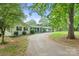 View of home on a tree-covered lot with an extended driveway and well-maintained lawn at 108 Augusta Dr, Statesville, NC 28625