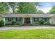 Charming one-story home with light blue siding, mature landscaping, a welcoming entrance and a well-manicured lawn at 108 Augusta Dr, Statesville, NC 28625