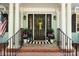 Welcoming front porch featuring a black front door with floral accents, a black railing, and potted flowers at 108 Augusta Dr, Statesville, NC 28625
