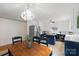 Eat-in kitchen featuring white cabinets, blue island, stainless fridge and a decorative chandelier at 108 Augusta Dr, Statesville, NC 28625