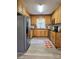 Well-lit kitchen with stainless steel appliances, warm wood cabinets, black countertops and modern flooring at 11 N 10Th Ave, Maiden, NC 28650