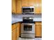 Kitchen featuring stainless steel appliances, oak cabinets, black countertop, and white subway tile backsplash at 11 N 10Th Ave, Maiden, NC 28650