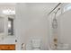 Clean bathroom features a toilet, shower-tub combination, large mirror, and simple vanity at 111 Wilton Pl, Mooresville, NC 28117