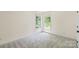 This well lit bedroom has neutral carpet, two large windows, and closet space at 111 Wilton Pl, Mooresville, NC 28117