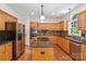 Gourmet kitchen with stainless appliances, island, custom cabinets, and hardwood floors at 111 Wilton Pl, Mooresville, NC 28117