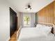 Bright bedroom featuring wood slat accent wall, ceiling fan, and window views to the outdoors at 1207 Carlson Dr, Monroe, NC 28110