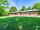 Charming brick home with a well-manicured lawn and mature trees at 1207 Carlson Dr, Monroe, NC 28110