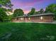 Charming brick home with manicured lawn and lush trees under a colorful sky at 1207 Carlson Dr, Monroe, NC 28110