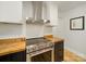 Updated kitchen with stainless steel oven and vent hood, butcher block counters, and white cabinets at 1207 Carlson Dr, Monroe, NC 28110