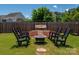 Charming backyard with a fire pit, rocking chairs, and a cozy swing, perfect for outdoor relaxation and entertainment at 12802 Waterlyn Club Dr, Charlotte, NC 28278