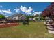 Expansive backyard featuring a cozy swing, fire pit with rocking chairs, and a lush green lawn for outdoor enjoyment at 12802 Waterlyn Club Dr, Charlotte, NC 28278
