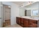 Bathroom featuring double sinks, a large mirror, a tiled floor, and a walk-in closet at 12802 Waterlyn Club Dr, Charlotte, NC 28278