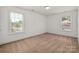 Light-filled bedroom featuring two windows and neutral carpeting, offering a comfortable and inviting space at 12802 Waterlyn Club Dr, Charlotte, NC 28278