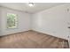 Neutral bedroom with a large window offering plenty of natural light and cozy carpet flooring at 12802 Waterlyn Club Dr, Charlotte, NC 28278