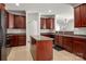 Kitchen with wood cabinets, island, tile floors and modern appliances with adjacent living space at 12802 Waterlyn Club Dr, Charlotte, NC 28278