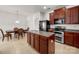 Kitchen with wood cabinets, island, stainless appliances, and adjacent dining area at 12802 Waterlyn Club Dr, Charlotte, NC 28278