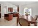 Open-concept kitchen and dining area with wood cabinets, island and French doors to backyard at 12802 Waterlyn Club Dr, Charlotte, NC 28278