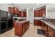 Spacious kitchen featuring wood cabinetry, stainless steel appliances, island, and tile flooring at 12802 Waterlyn Club Dr, Charlotte, NC 28278