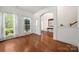 Bright living room with hardwood floors, large windows with white curtains, and arched doorways at 12802 Waterlyn Club Dr, Charlotte, NC 28278